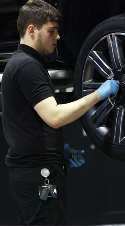 male apprentice working on car tyre