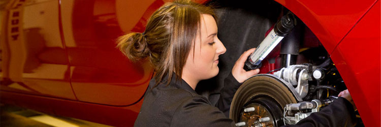 female apprentice working on car